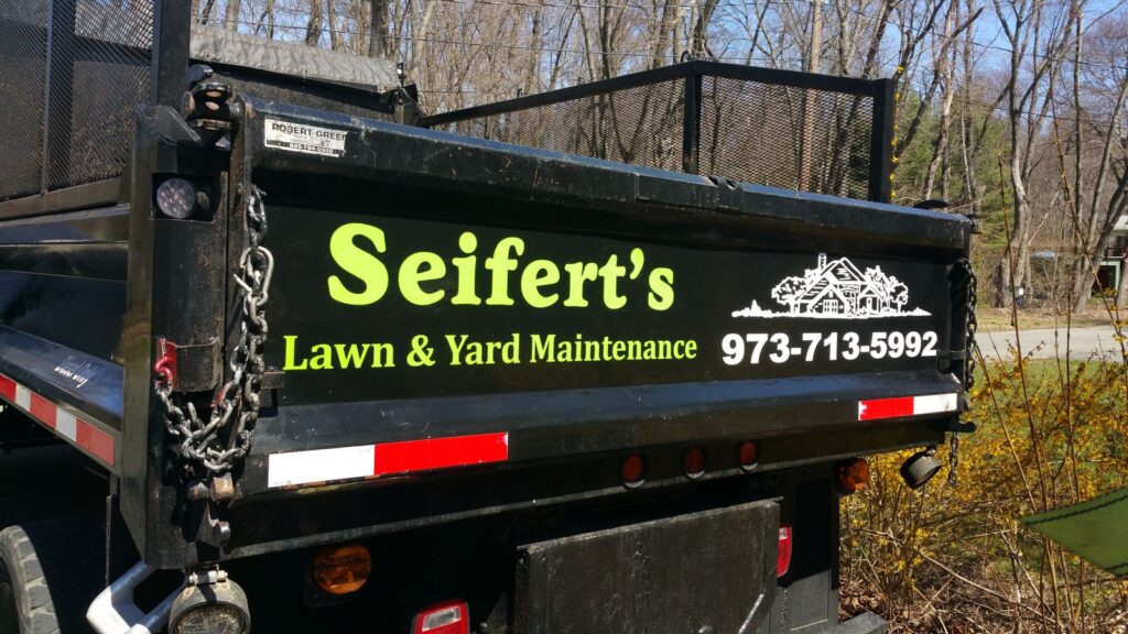 Seifert's Lawn & Yard Maintenance tailgate lettering with phone number on a black dump truck, Budd Lake NJ