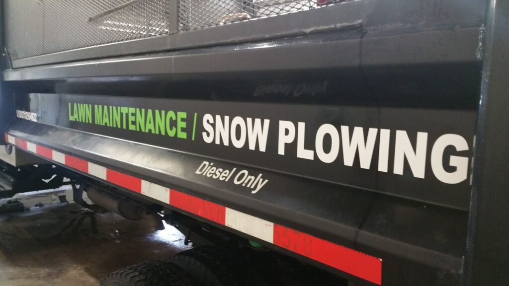 Lawn Maintenance / Snow Plowing vinyl lettering on the side of a black dump body, Budd Lake NJ